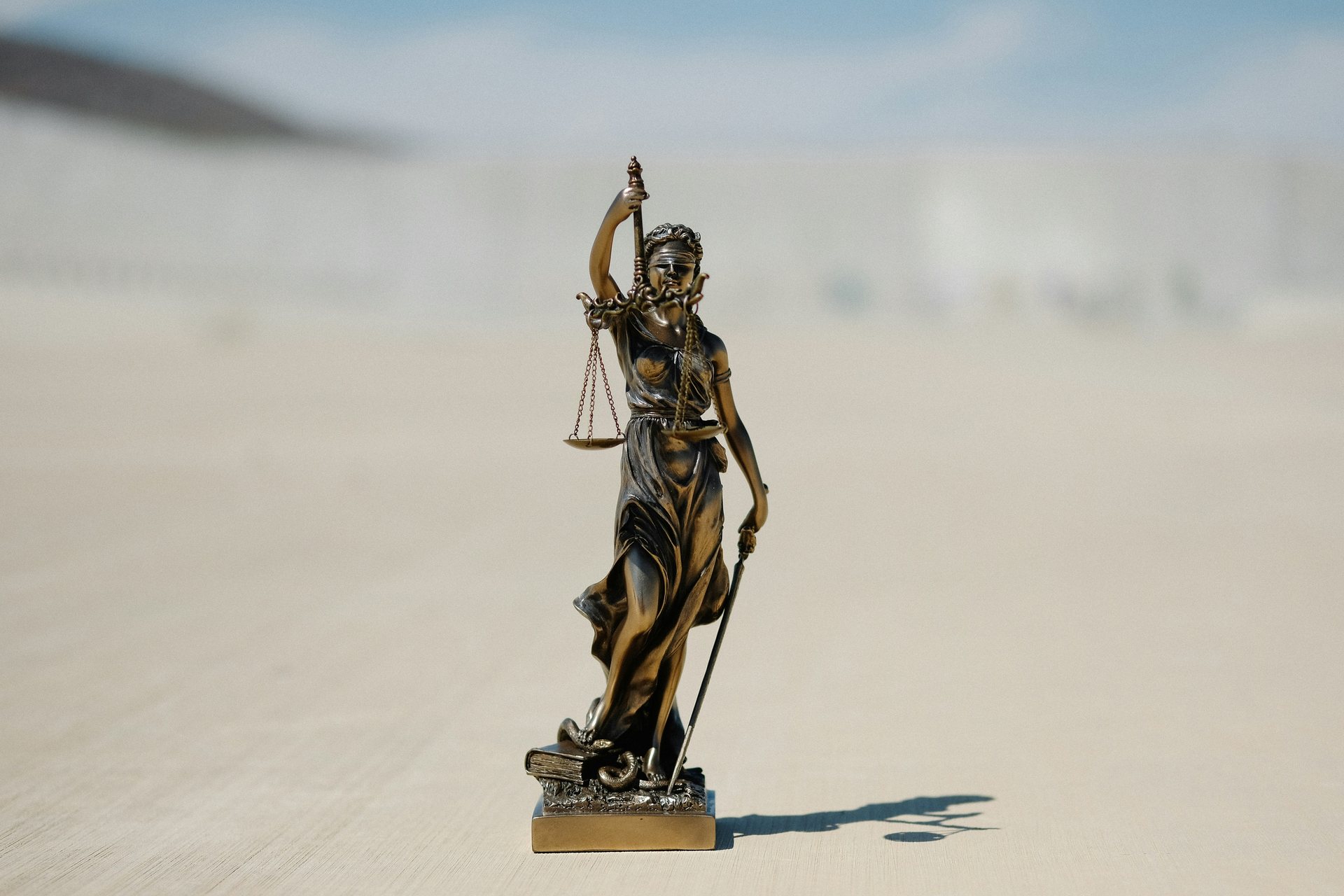 Estátua da justiça com balança em ambiente jurídico